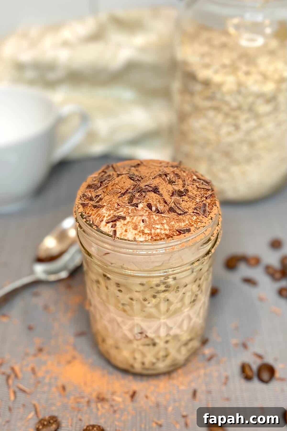 Tiramisu oats in a mason jar, sprinkled with cocoa and chocolate shavings on top.