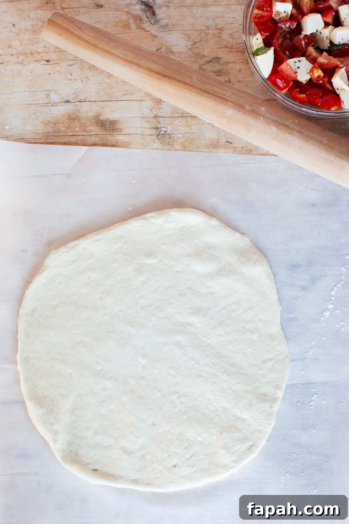 Homemade Pizza Sauce Recipe for Authentic, Restaurant-Quality Flavor 5 Thin crust pizza dough flatly rolled out on parchment paper.