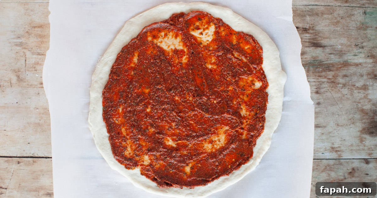 Homemade Pizza Sauce Recipe for Authentic, Restaurant-Quality Flavor 7 pizza sauce spread on an uncooked dough.
