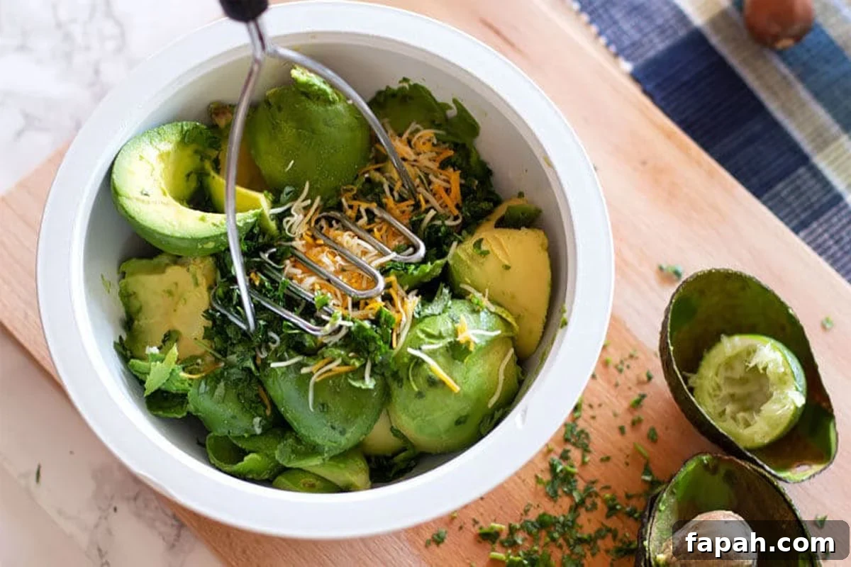 Creamy Homemade Guacamole Recipe for Parties and Everyday Meals 8 Using a potato masher to mash the ingredients together for guacamole.