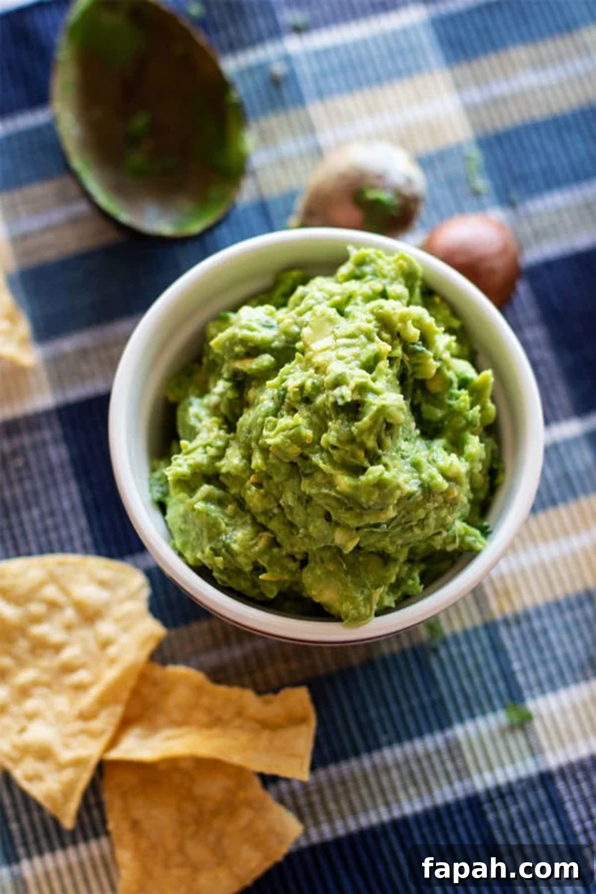 Creamy Homemade Guacamole Recipe for Parties and Everyday Meals 9 Bowl of guacamole being served with chips.