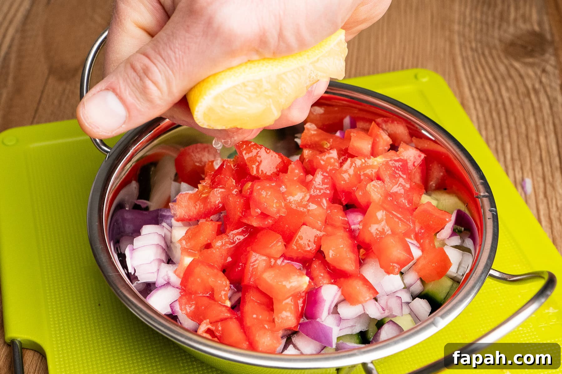 Squeezing half a lemon juice onto onion salad in a Balti dish