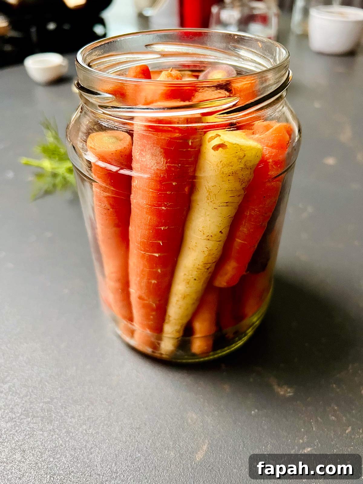 Carrots arranged nicely in a jar, ready to get the water poured over for pickling.