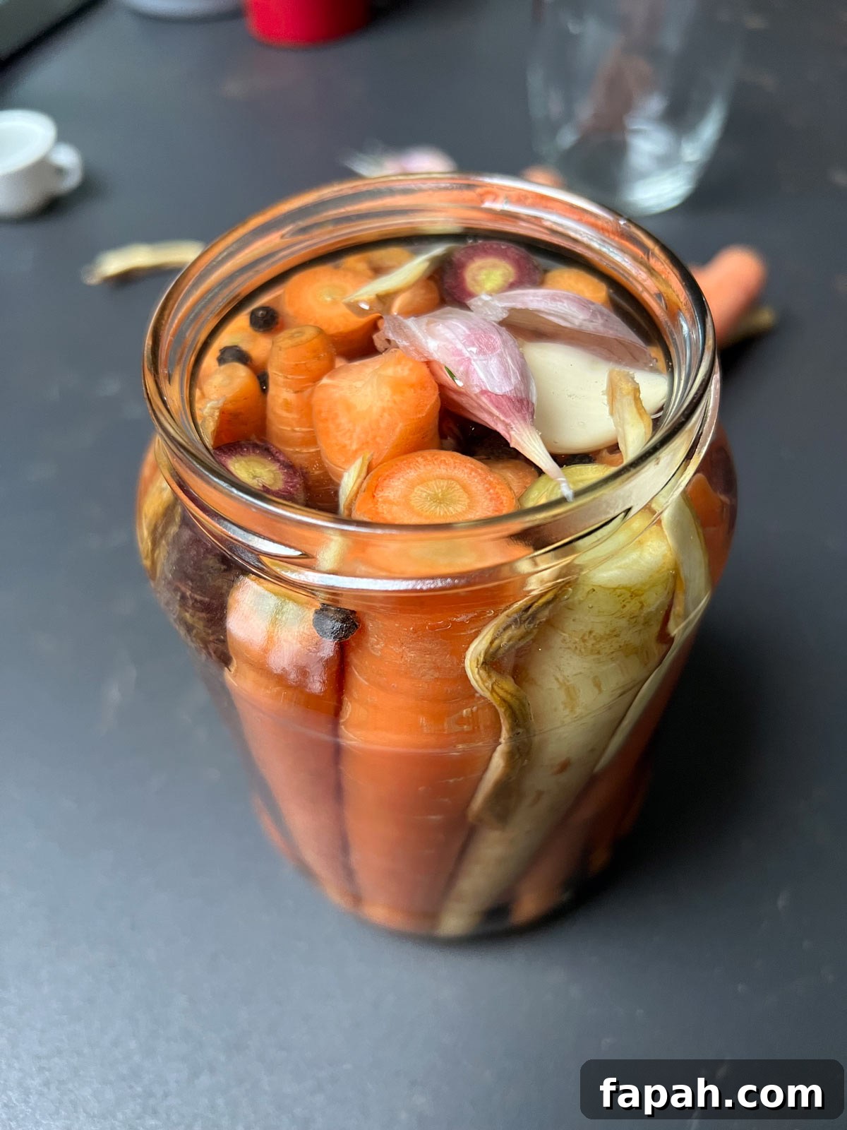 The last step to pickle, carrots, water poured over and all ingredients in a jar.