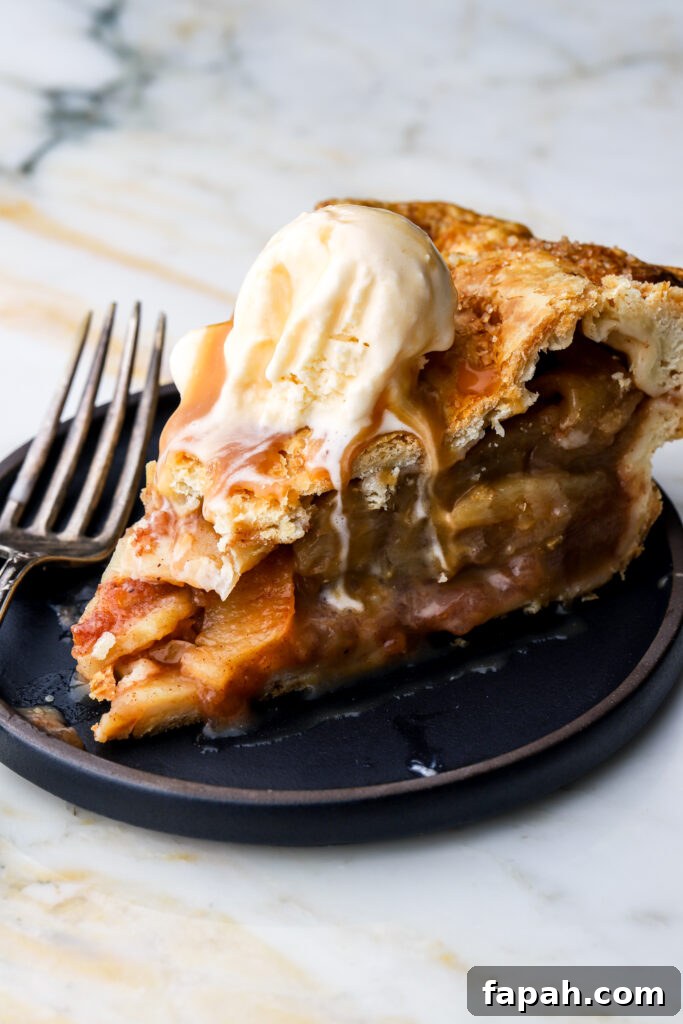 slice of apple pie with vanilla ice cream on a plate