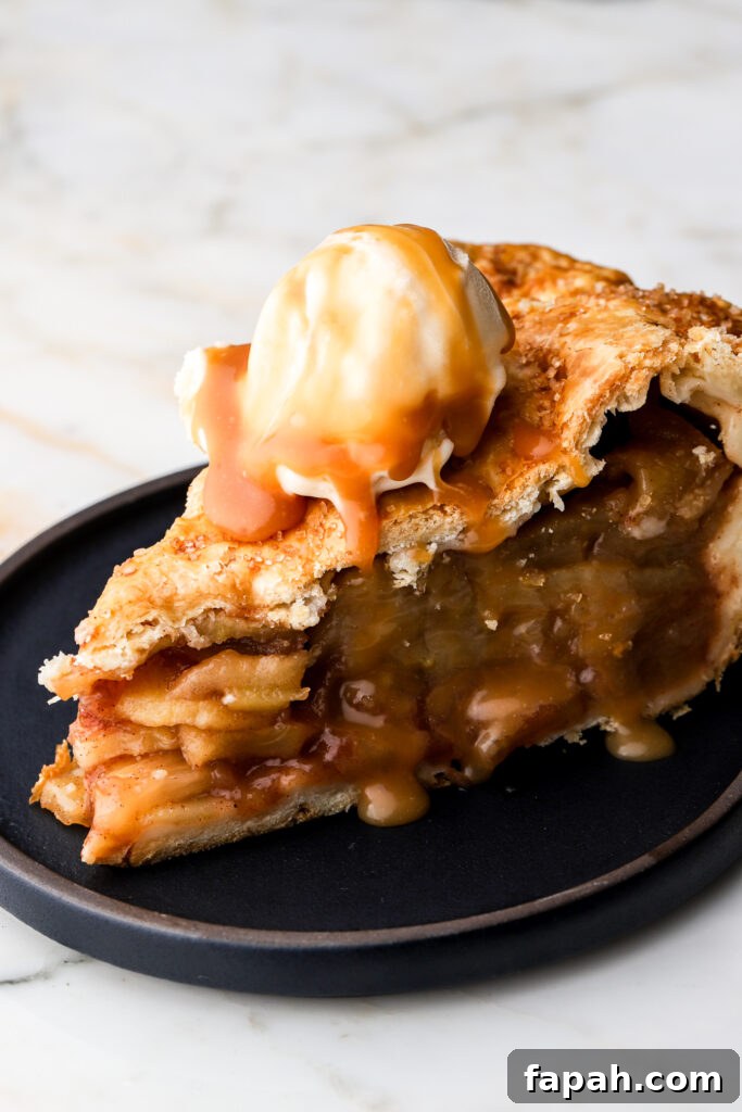 slice of apple pie with vanilla ice cream on a plate