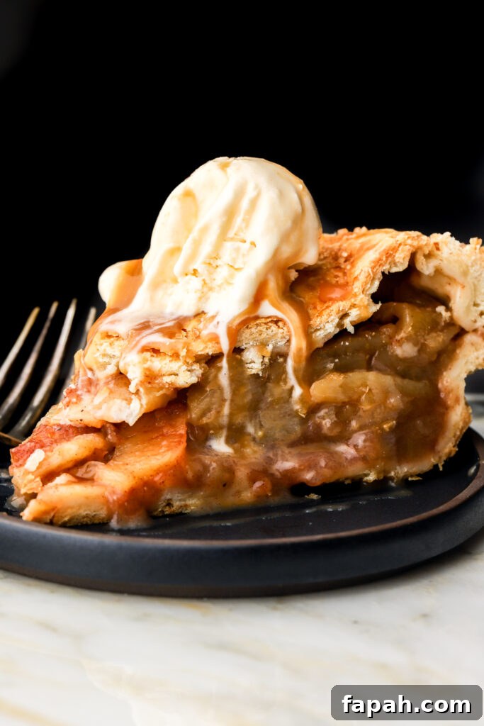 slice of apple pie with vanilla ice cream on a plate