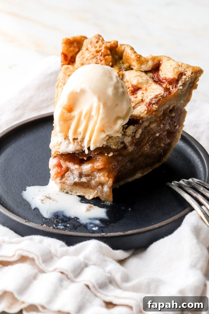 slice of apple pie on a plate with vanilla ice cream