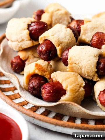 Gluten free pigs in a blanket in a pile on a plate.