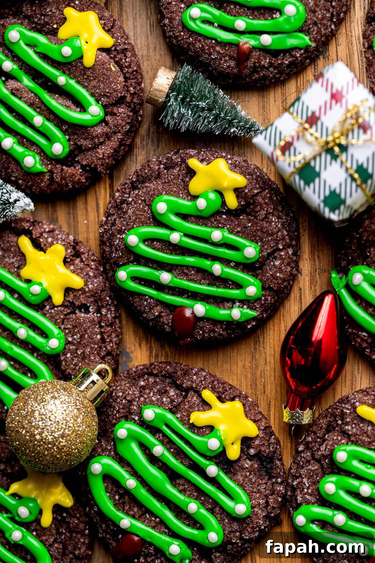 Festive Christmas Tree Cookie Recipes for Holiday Baking 2 Christmas tree cookies with Christmas decorations around it.
