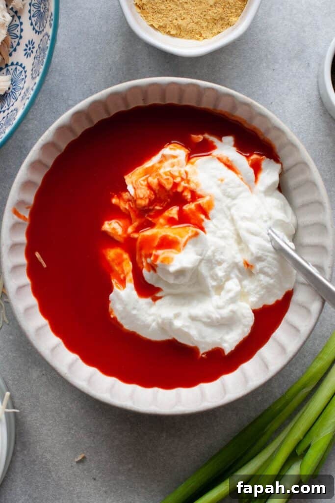 mixing greek yogurt and buffalo sauce together
