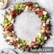 Christmas charcuterie board in a wreath shape with various meats, cheese and fruit.