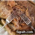 Crispy roast duck being easily shredded with two forks