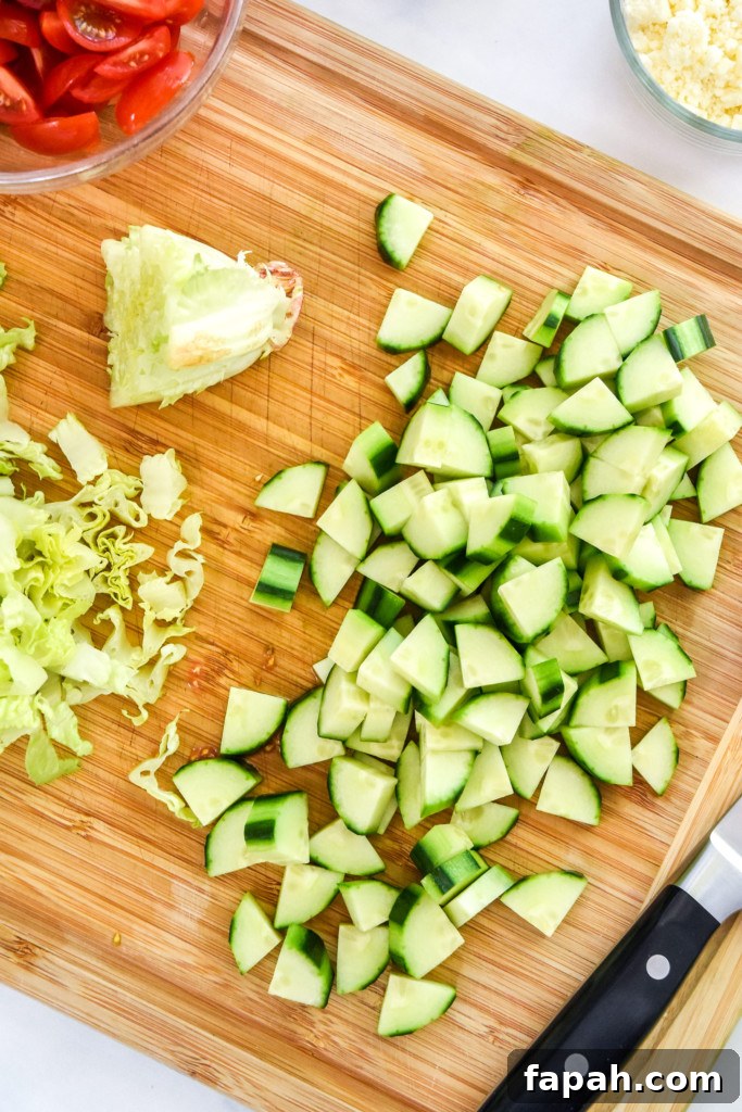 peeling and chopping the cucumber for the greek chicken salad meal prep bowls.