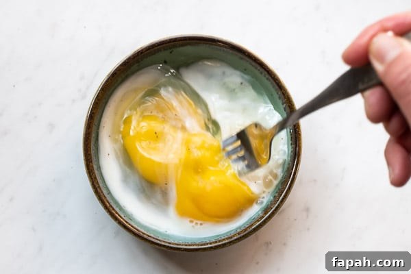 Cheesy Microwave Scrambled Eggs in 2 Minutes 3 Eggs and milk beaten together with a fork in a microwave safe bowl