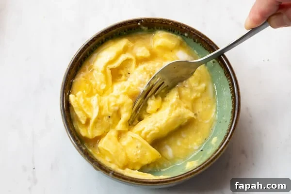 Cheesy Microwave Scrambled Eggs in 2 Minutes 6 Mostly cooked eggs being stirred a second time