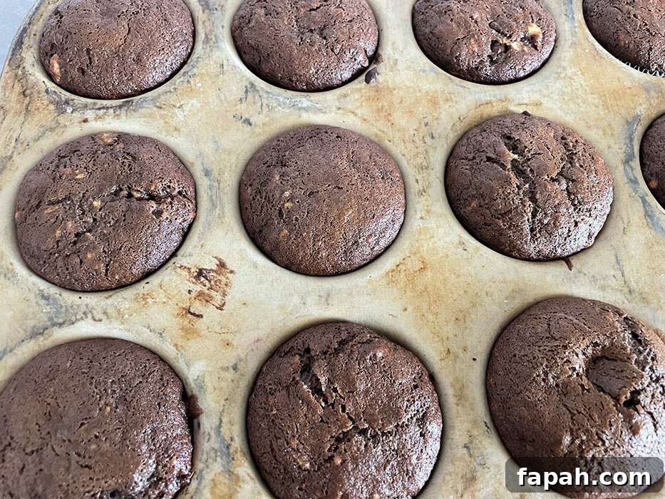 A stoneware muffin pan filled with double chocolate banana muffins.