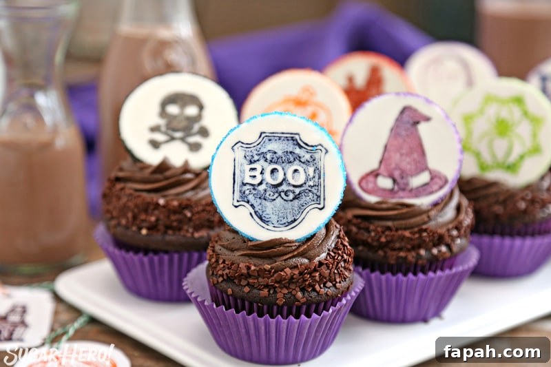 Stamped Halloween Cupcakes - group of chocolate cupcakes with cute Halloween-themed fondant circles on top | From SugarHero.com