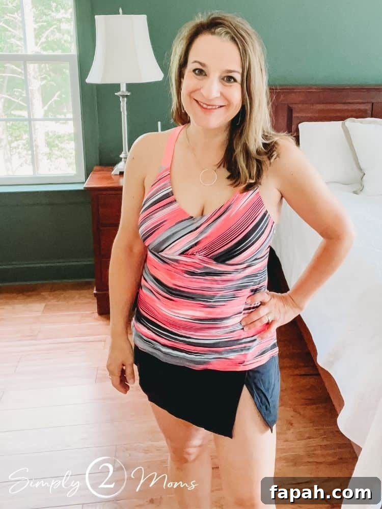 Woman wearing a striped tankini top with a V neck and black swim skirt with a slit