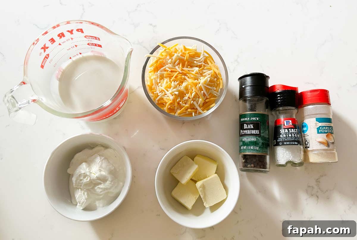 Cheesy mashed potatoes ingredients on a white kitchen counter.
