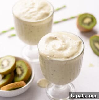 two glasses of smoothie with straws and kiwi on the side
