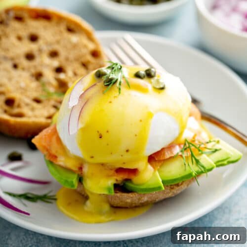 Smoked Salmon eggs Benedict with sliced avocado on a white plate
