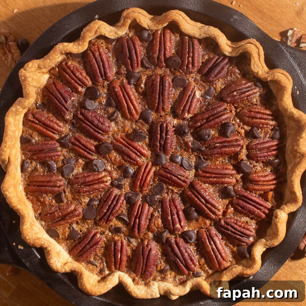 Chocolate Chip and Pecan Pie Recipe: Chocolate-Pecan Pie Guide 3 Golden chocolate chip pecan pie recipe baked in a cast iron pan with pecans and chocolate chips on top.