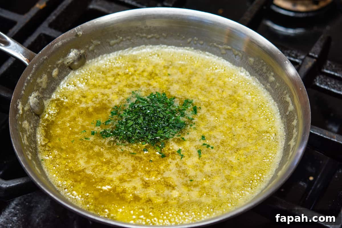 adding parsley and lemon zest to butter and garlic in skillet