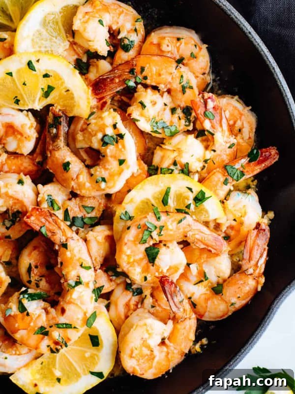Lemon Garlic Butter Shrimp with lemon slices in a cast iron skillet