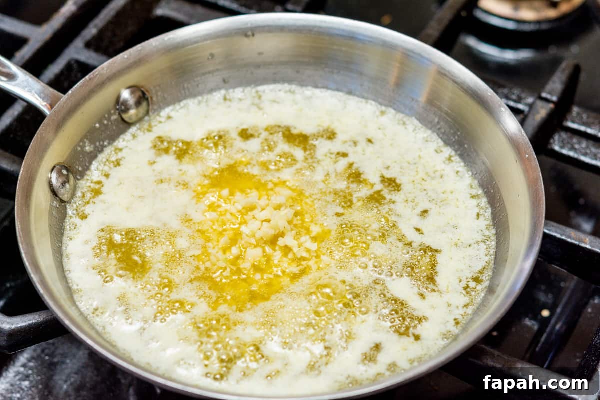 adding garlic to melted butter in skillet