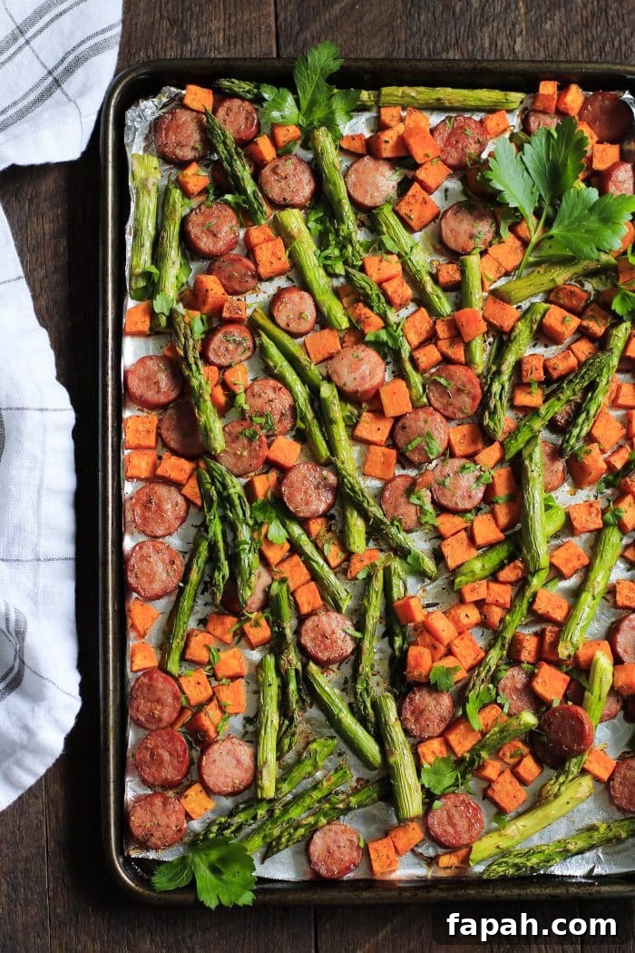 60 Delicious Whole30 Recipes for Every Meal and Snack 21 overhead view of asparagus, sweet potato and sausage on a baking sheet