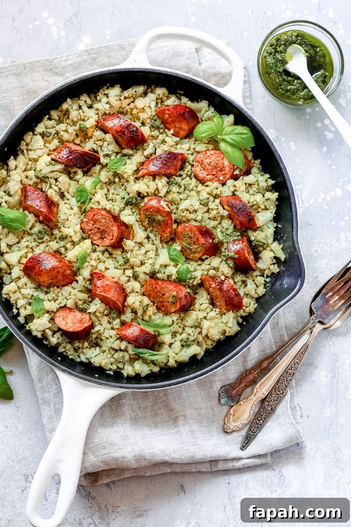 60 Delicious Whole30 Recipes for Every Meal and Snack 4 overhead view of a white skillet containing Italian Sausage and Cauliflower Rice