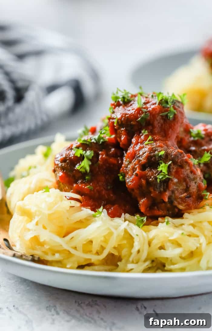 60 Delicious Whole30 Recipes for Every Meal and Snack 46 Close-up of half a spaghetti squash with meatballs on a white plate.