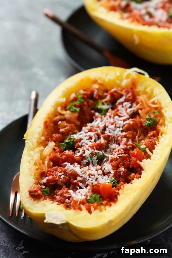 60 Delicious Whole30 Recipes for Every Meal and Snack 48 Close-up of half a spaghetti squash with Bolognese sauce on a black plate.