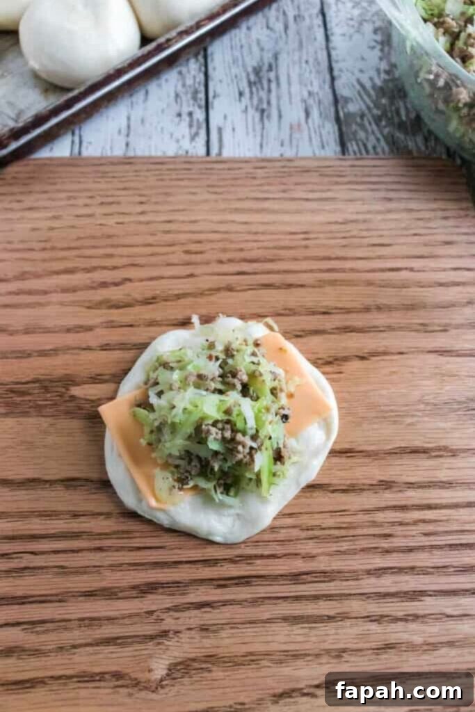 Quick Bierocks Made with Frozen Dinner Rolls: Simple Weeknight Recipe 6 Raw bread dough with a slice of cheese and meet and cabbage filling in the center