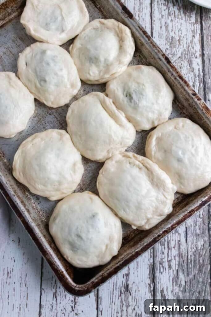 Quick Bierocks Made with Frozen Dinner Rolls: Simple Weeknight Recipe 8 bierocks in raw form on a baking sheet on table