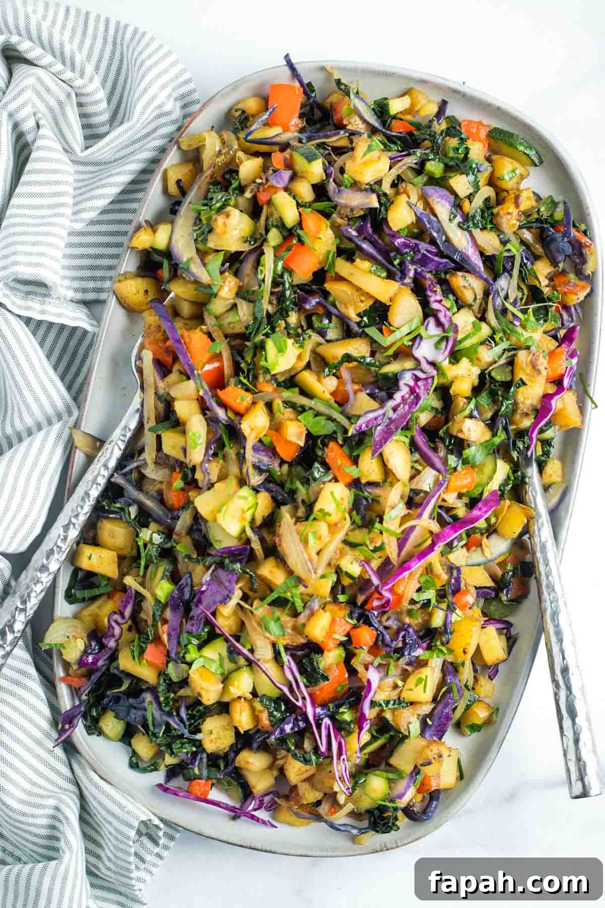 Vegetable and potato hash with bright and colorful cabbage, red peppers, kale and zucchini. 