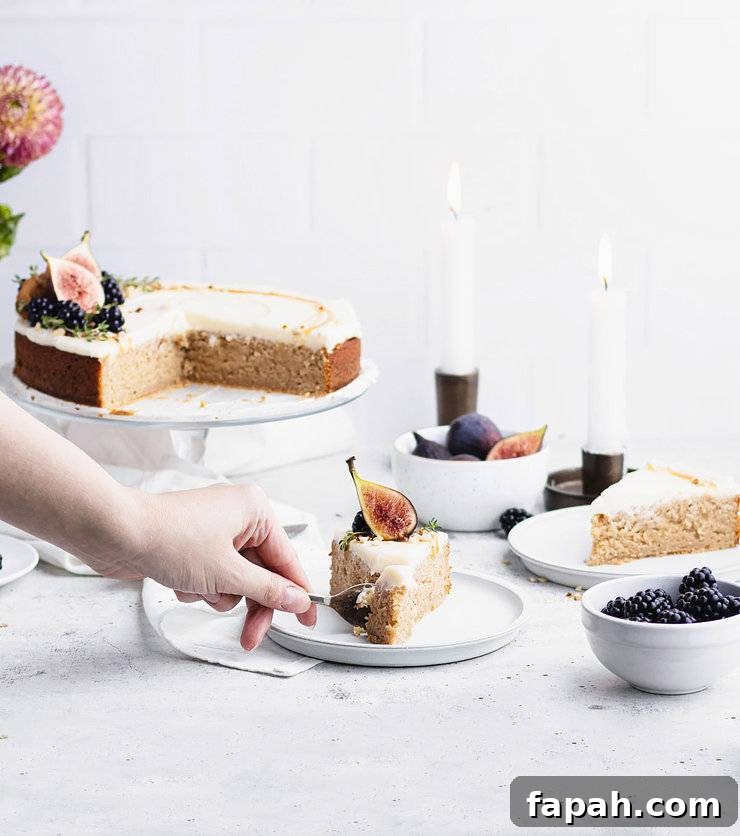 Hand cutting into a plated slice of kyrdderkake with the larger cake, two lit taper candles and another slice slightly blurred in the background.