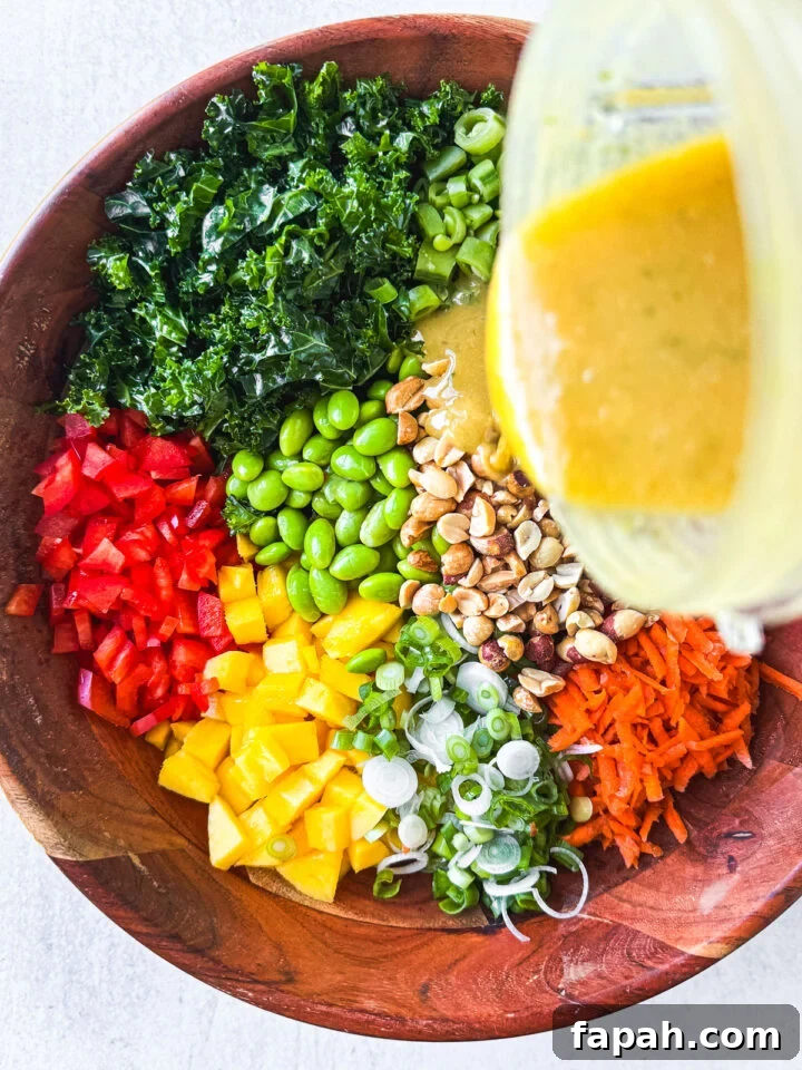 Peanut dressing being poured over vegetables in a bamboo serving bowl.