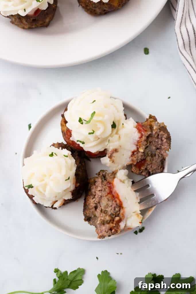 3 meatloaf cupcakes on a white plate with a fork.