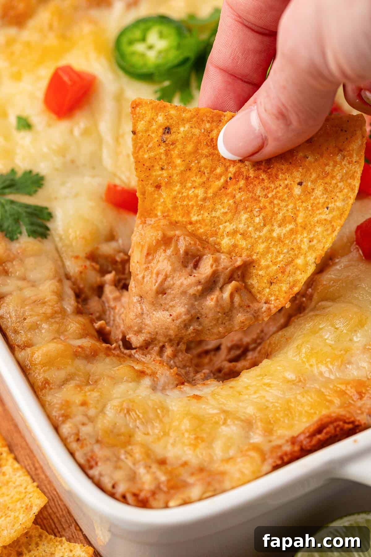 dipping a chip into cream cheese bean dip
