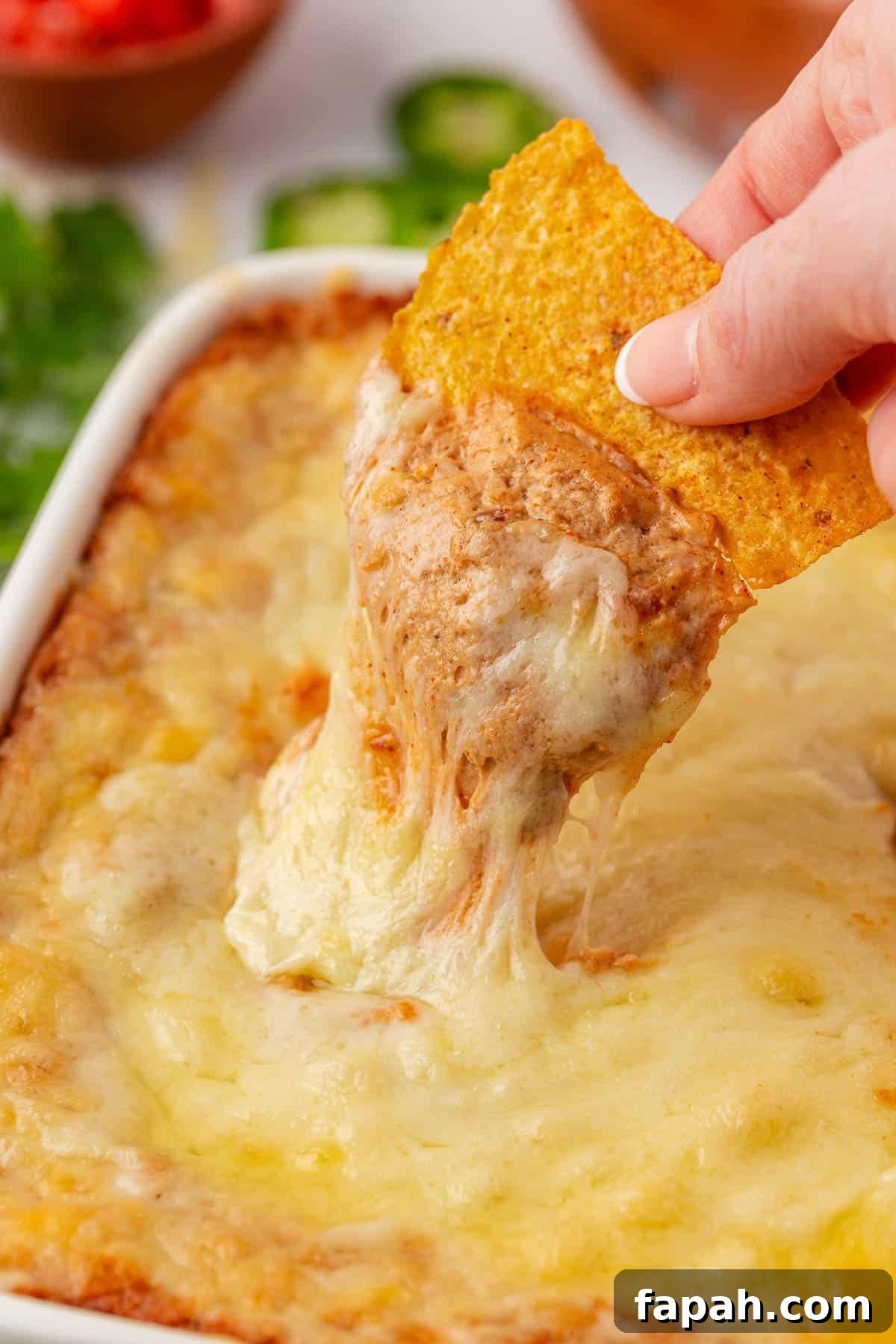 dipping a chip into cream cheese bean dip