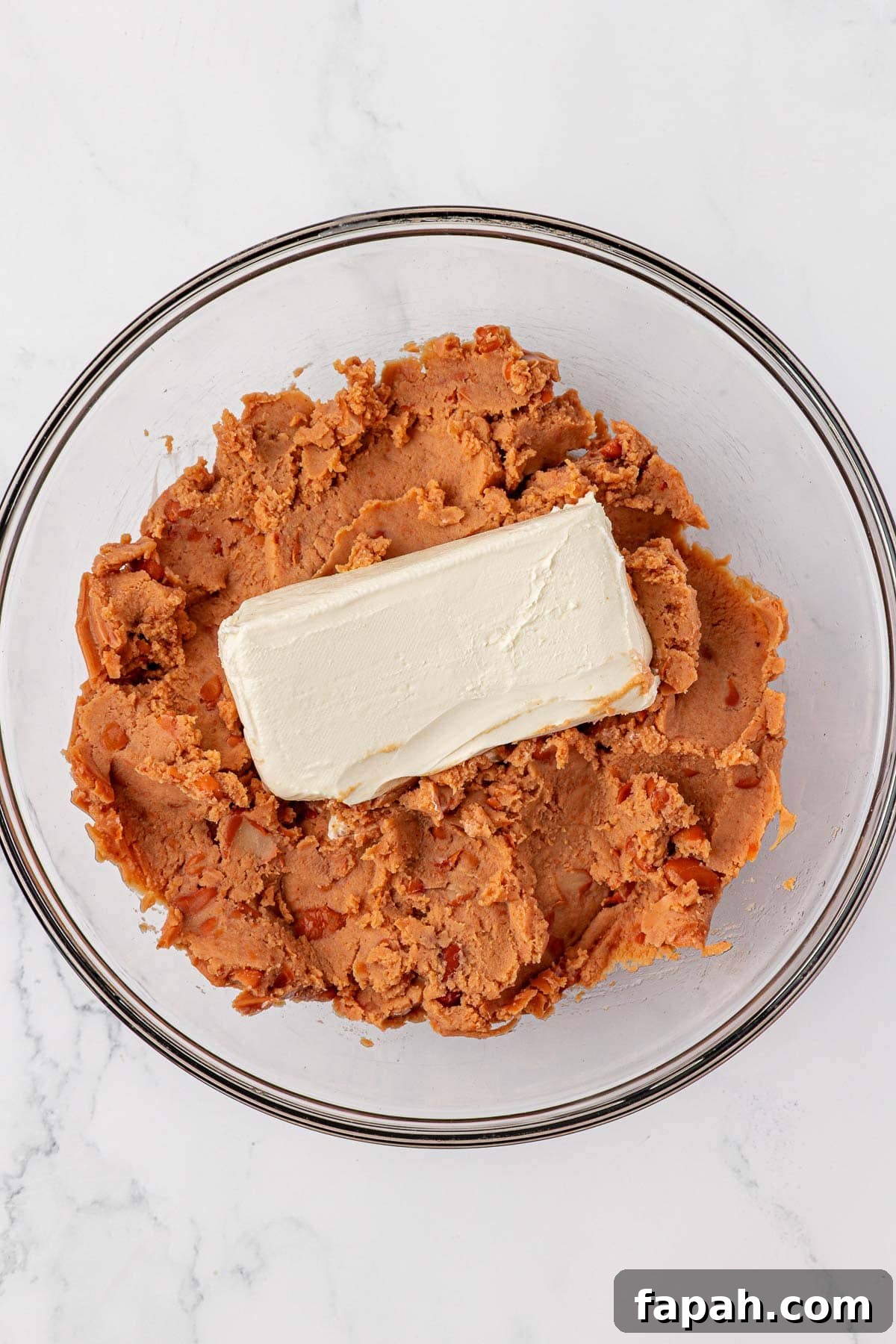 refried beans and cream cheese in a mixing bowl