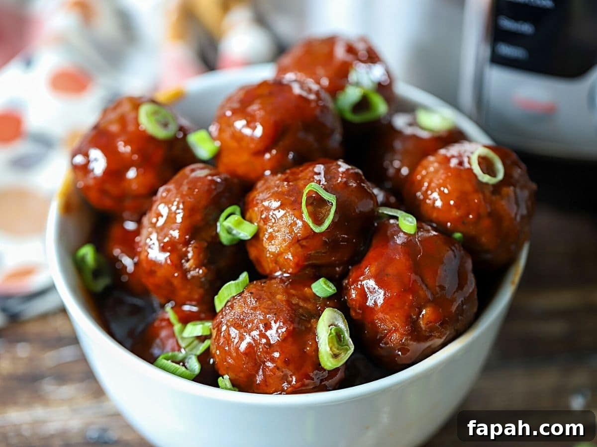 Instant Pot Grape Jelly Meatballs Recipe for Quick Weeknights 2 Meatballs in a serving dish.