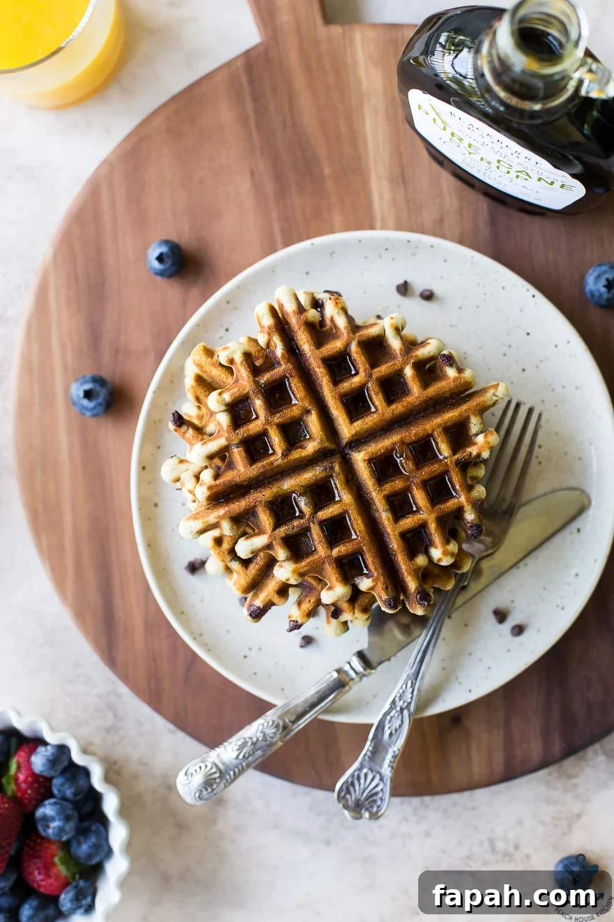 Chocolate Chip Banana Bread Waffles Recipe — Crispy Banana-Chip Waffles 2 Overhead photo of chocolate chip banana bread waffles on a plate on a wooden board