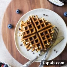 Chocolate Chip Banana Bread Waffles Recipe — Crispy Banana-Chip Waffles 11 Overhead photo of chocolate chip banana bread waffles on a plate on a wooden board