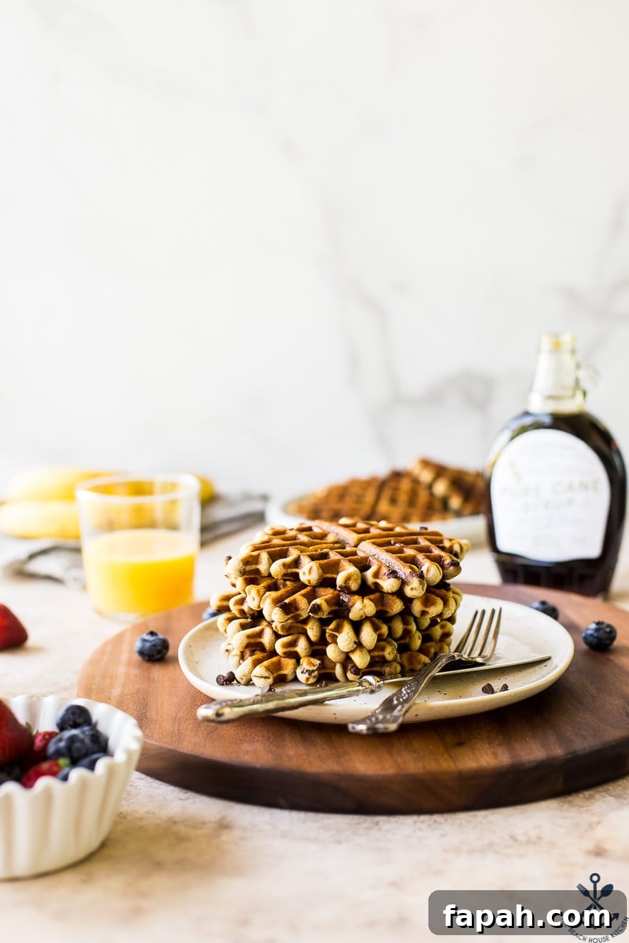 Chocolate Chip Banana Bread Waffles Recipe — Crispy Banana-Chip Waffles 3 Plate of chocolate chip banana bread waffles on a plate on a wooden serving board
