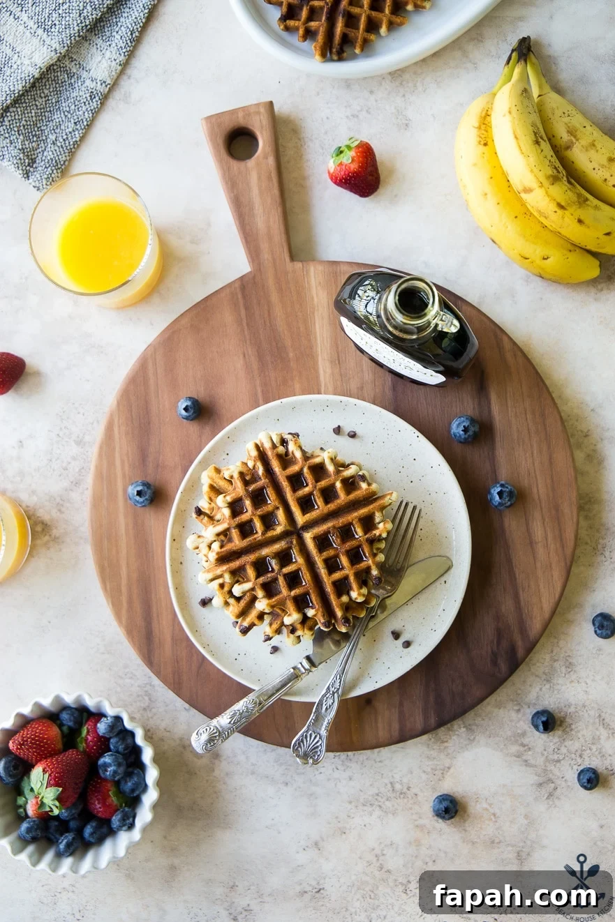 Chocolate Chip Banana Bread Waffles Recipe — Crispy Banana-Chip Waffles 4 Overhead photo of chocolate chip banana bread waffles on a plate on a wooden board