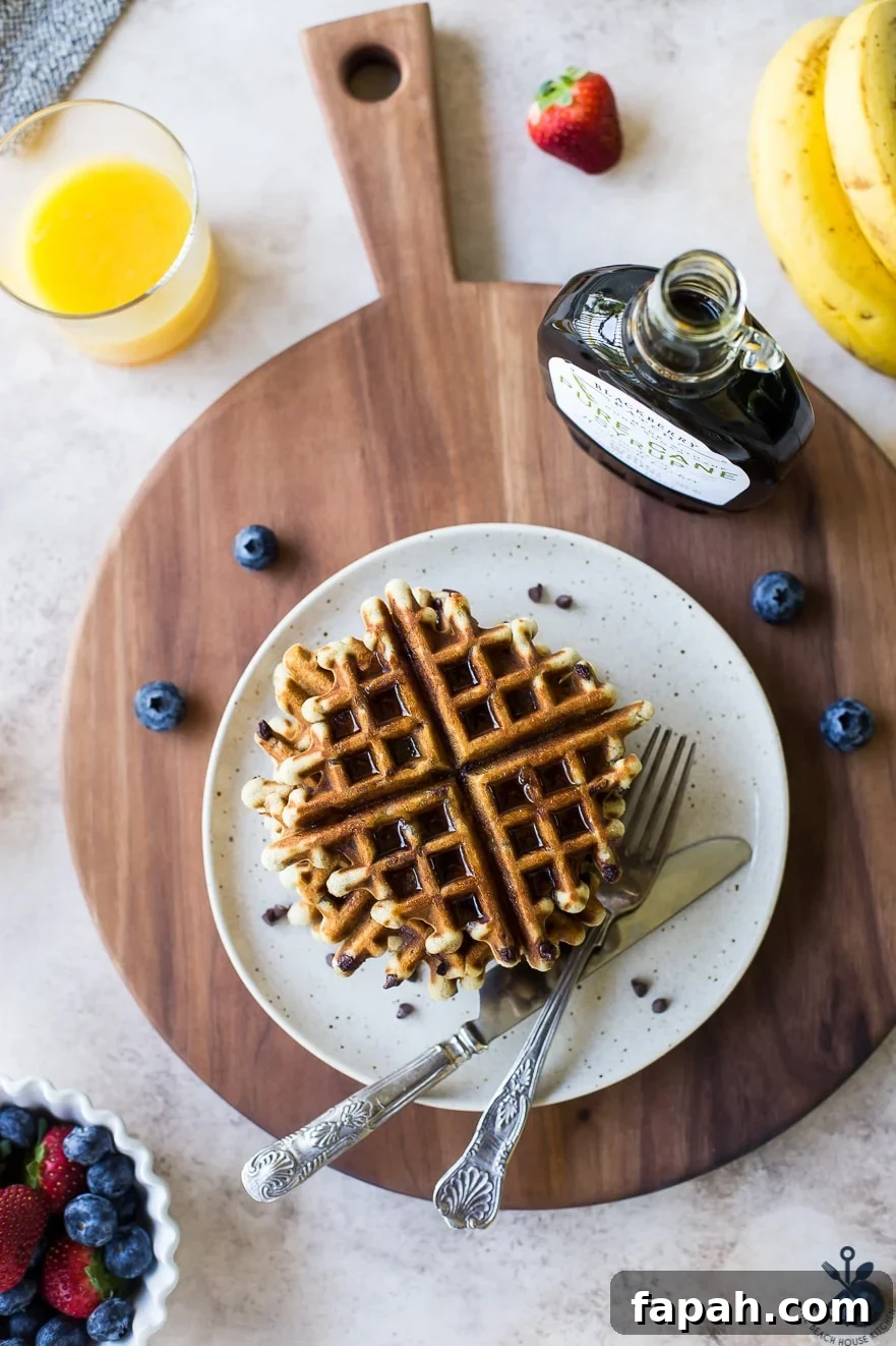Chocolate Chip Banana Bread Waffles Recipe — Crispy Banana-Chip Waffles 5 Overhead photo of chocolate chip banana bread waffles on a plate on a wooden board