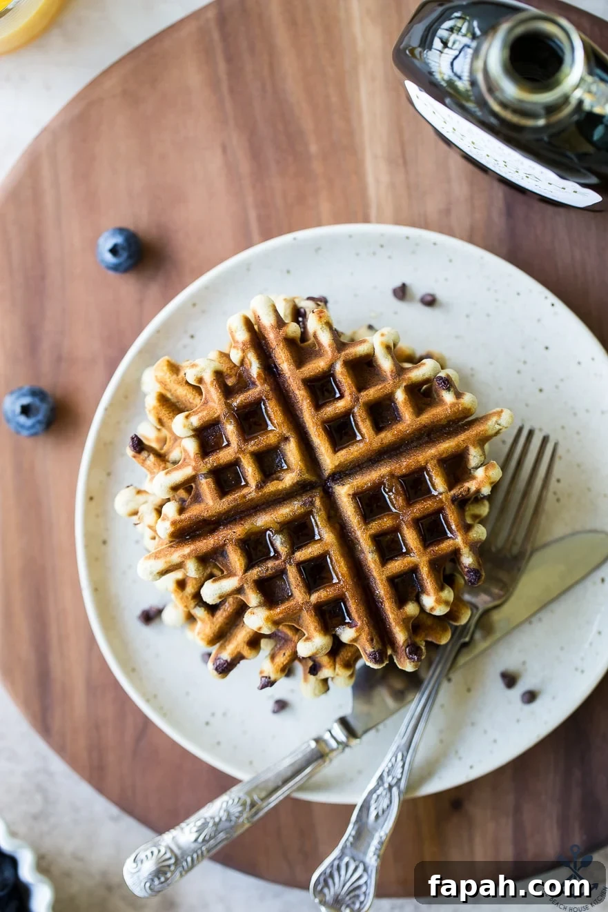 Chocolate Chip Banana Bread Waffles Recipe — Crispy Banana-Chip Waffles 7 Overhead photo of chocolate chip banana bread waffles on a plate on a wooden board